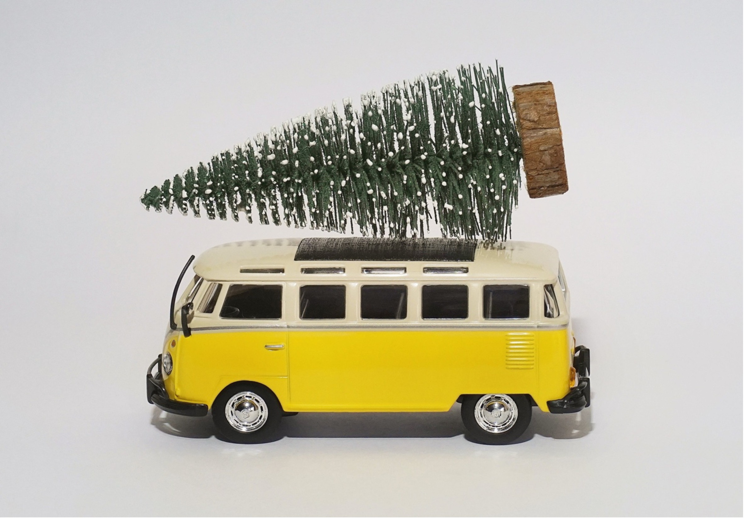 Yellow camper van with horizontal fir tree on its roof